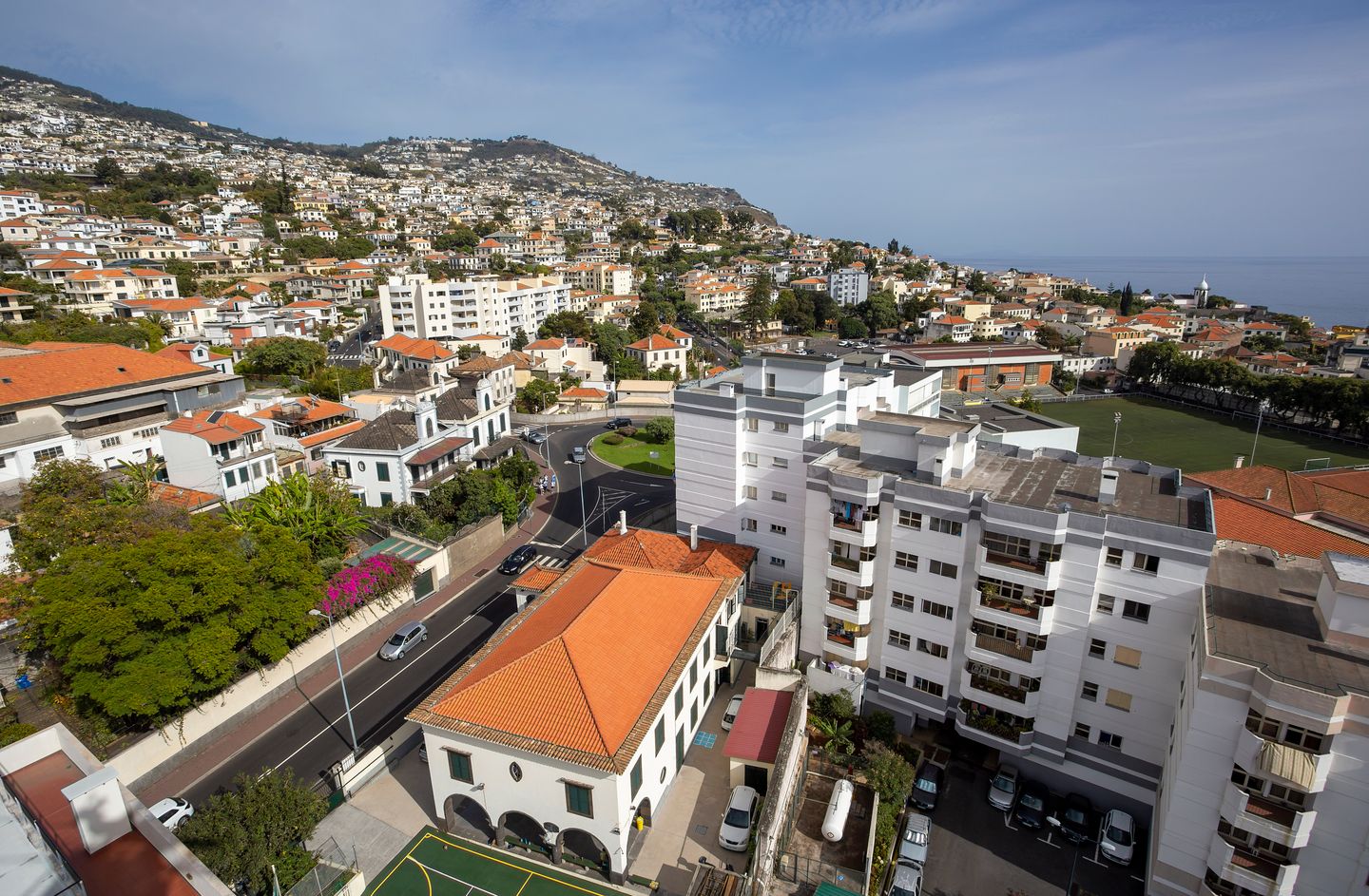 Vista aérea de Funchal, Madeira, mostrando techos rojos, edificios residenciales y la costa.