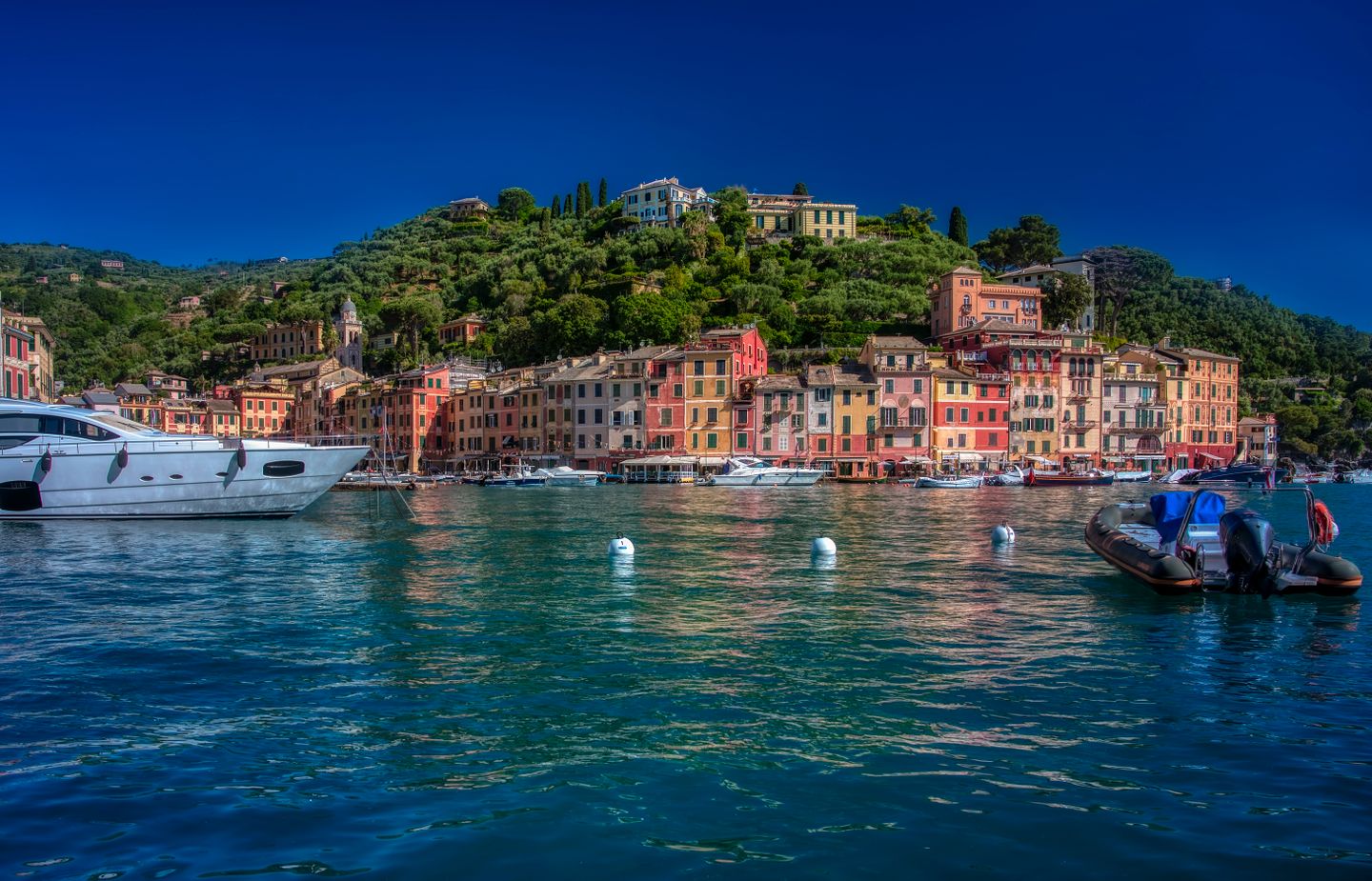 Hermosa vista del colorido paseo marítimo de Portofino con barcos en un día soleado.