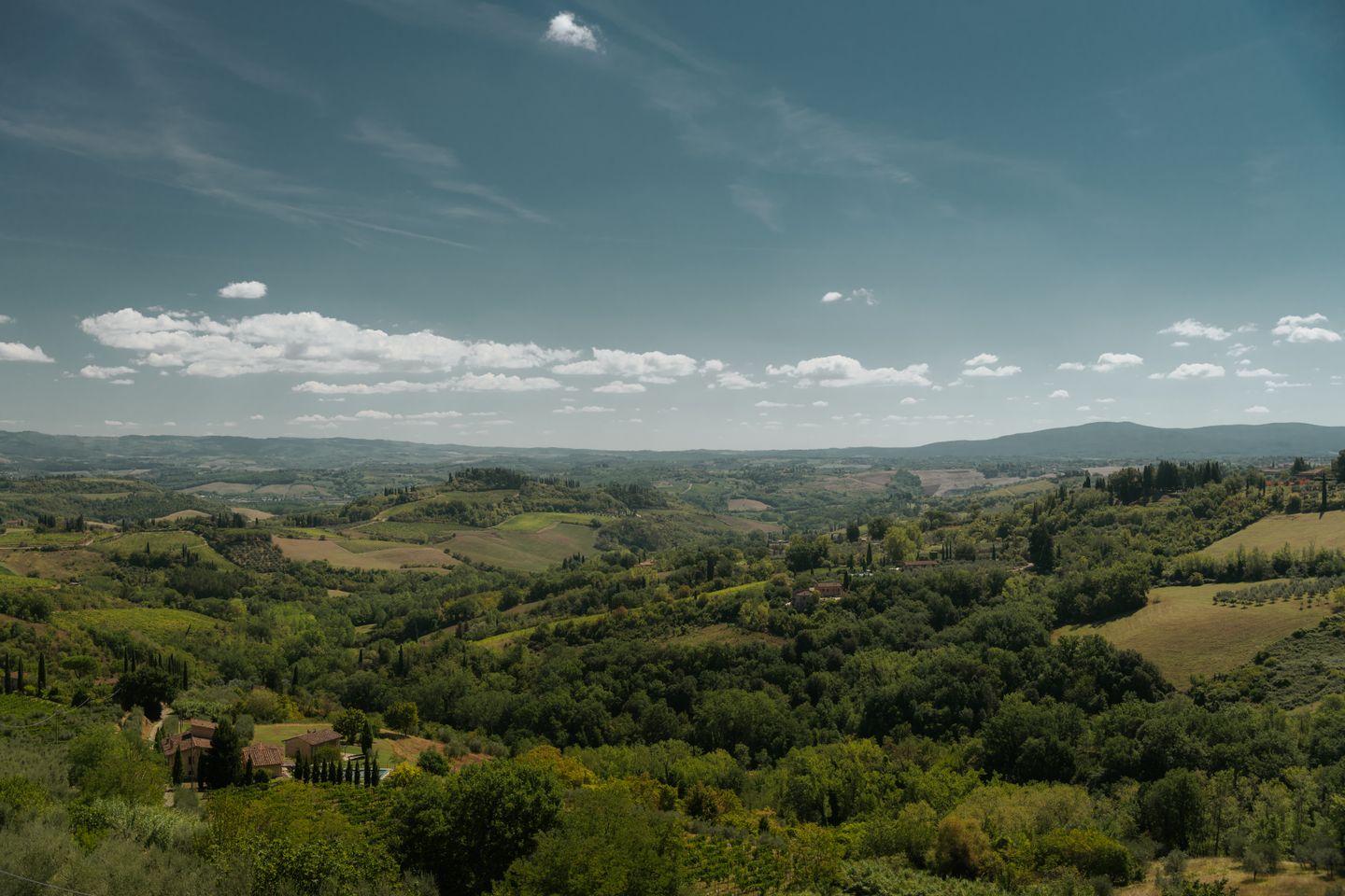 Una vista impresionante de las exuberantes colinas y campos de San Gimignano, Toscana, bajo un cielo despejado de verano.