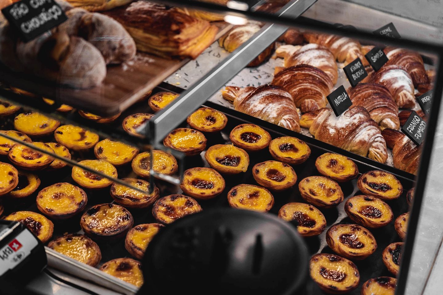 Muestra de pasteles de nata y croissants en una panadería de Lisboa. Delicias tentadoras en exhibición.