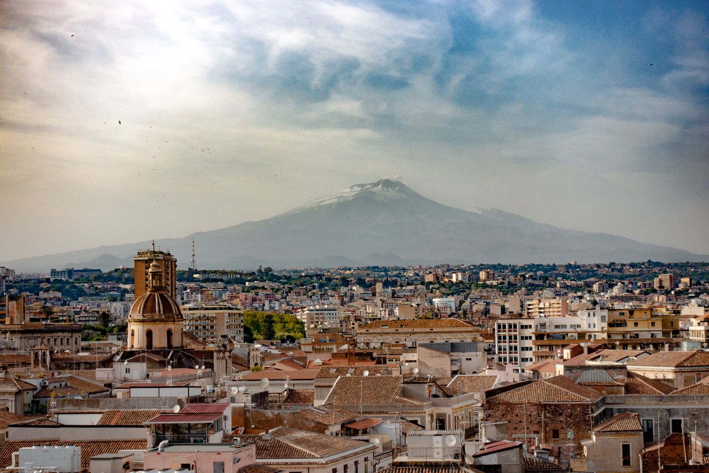 Un impresionante paisaje urbano de Catania, Sicilia, con el Monte Etna al fondo, mostrando la belleza urbana y natural.