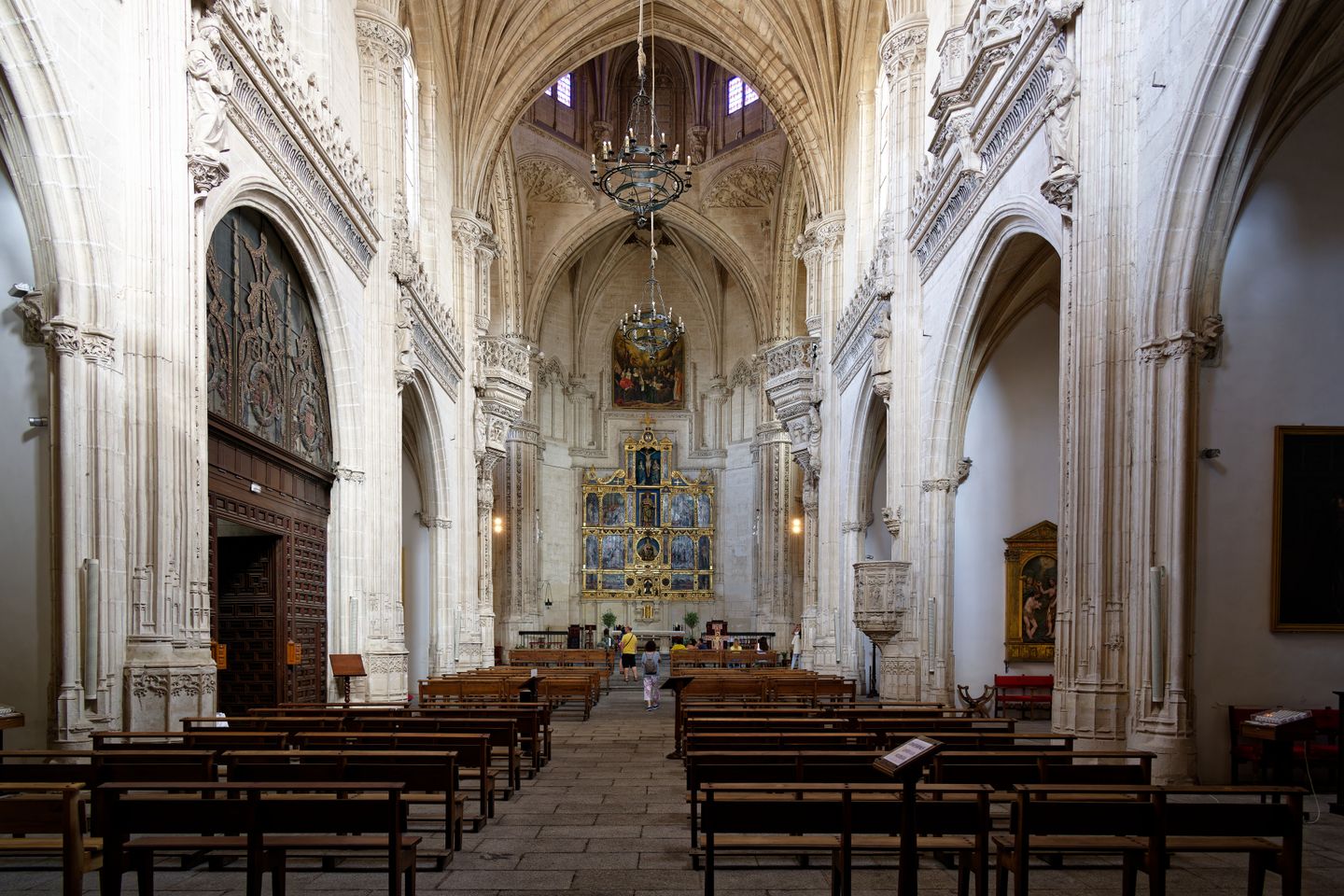 Vista interior de una catedral gótica en Toledo, España, que muestra su grandeza y detalles intrincados.