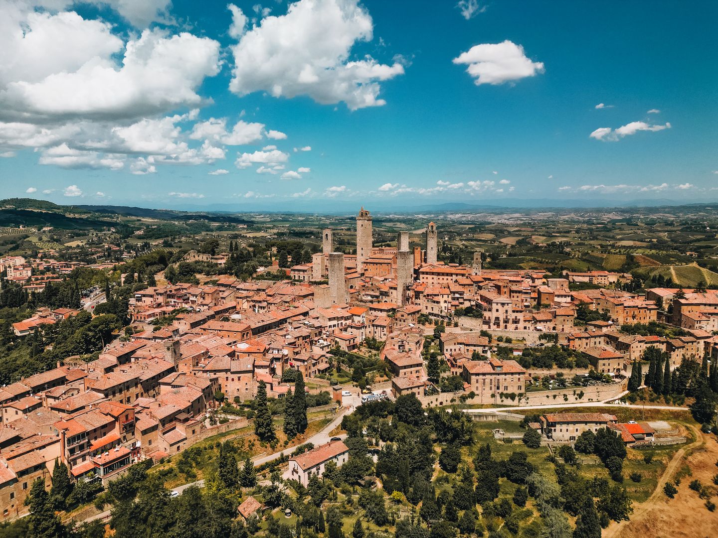 Impresionante vista aérea de la ciudad medieval de San Gimignano en Toscana, Italia, mostrando torres icónicas y paisajes escénicos.