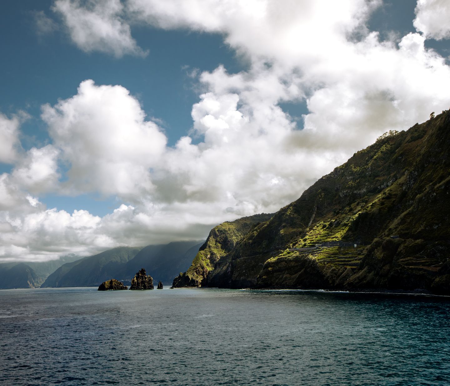 Impresionante vista escénica de la costa de Madeira con nubes dramáticas y acantilados rocosos.
