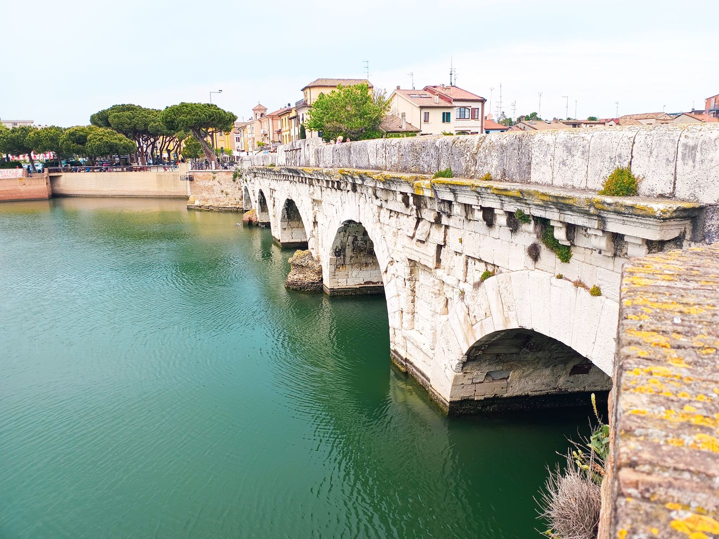 Explora el histórico Puente de Tiberio, un icónico puente romano en Rímini, Italia, que cruza el río Marecchia.