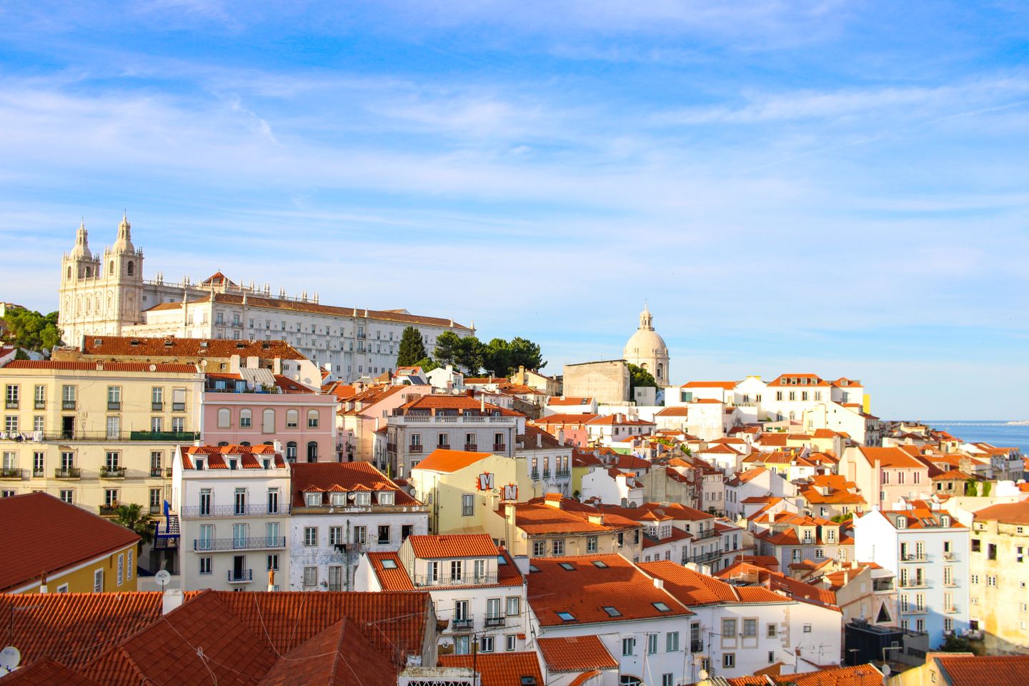 Una vista escénica del histórico barrio de Alfama en Lisboa que muestra la arquitectura tradicional bajo un cielo despejado.