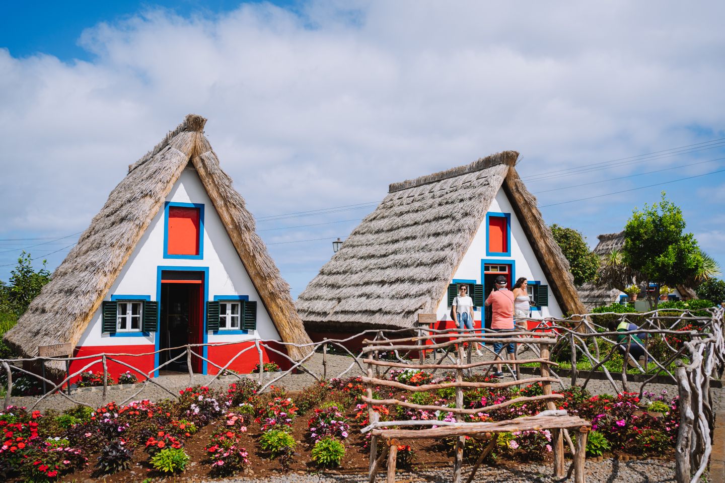 Pintorescas casas de Santana con techos de paja rodeadas de jardines en Madeira.