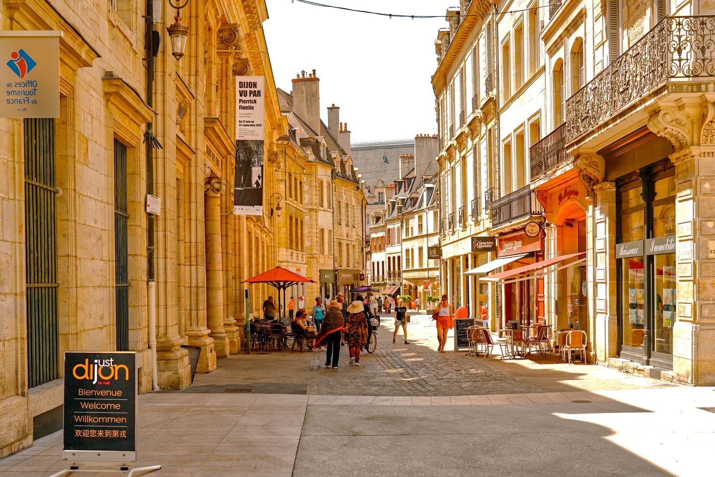 Calle pintoresca en Dijon, Francia, con arquitectura vintage y ambiente animado.