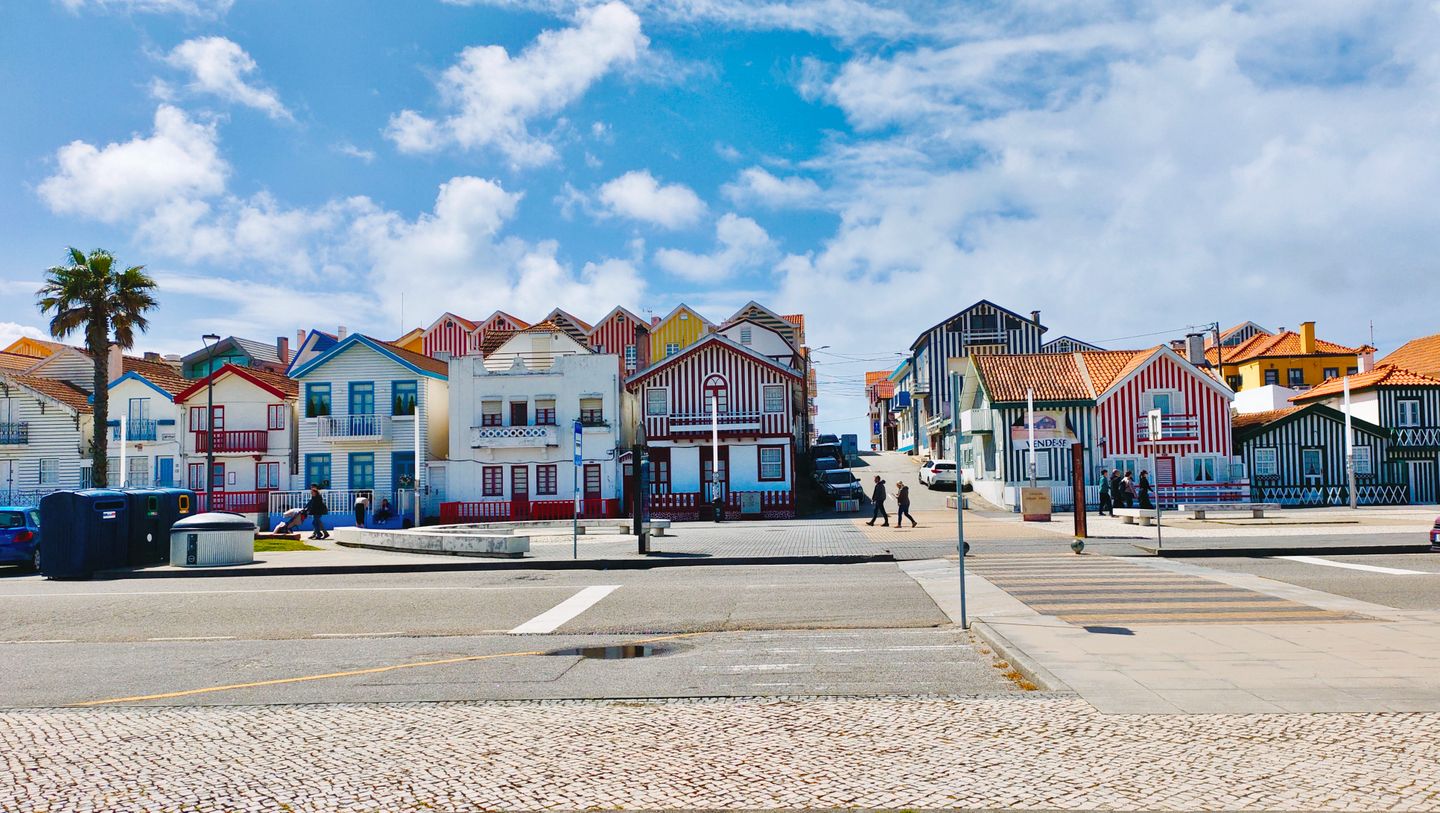 Casas de vibrantes rayas en Costa Nova, Aveiro, con cielos azules y despejados. Arquitectura costera portuguesa emblemática.