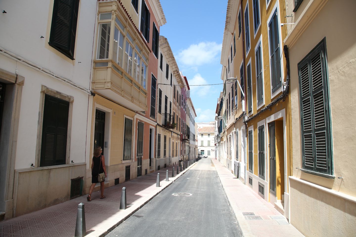 Calle idílica en Ciudadela de Menorca con arquitectura tradicional y colores vibrantes.