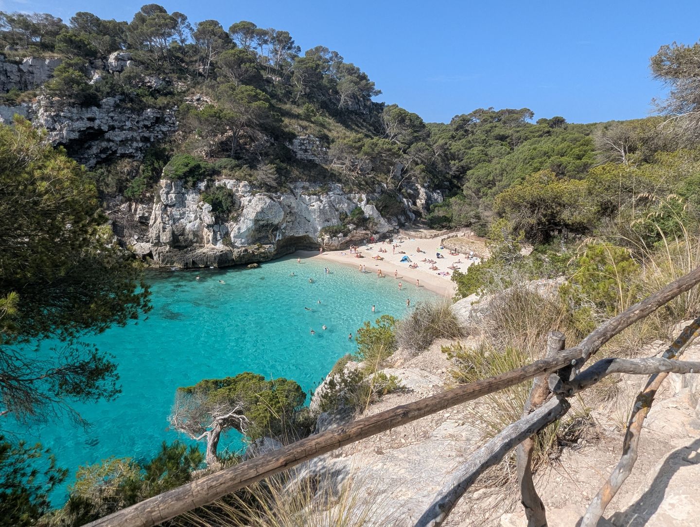 Idílica escena de playa en Cala Macarella, Ciutadella de Menorca, con agua turquesa.