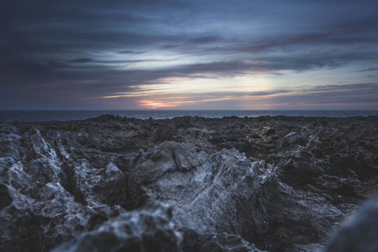 Explora la belleza escarpada de la costa de Ciudadela de Menorca al atardecer, mostrando espectaculares formaciones rocosas y un cielo colorido.