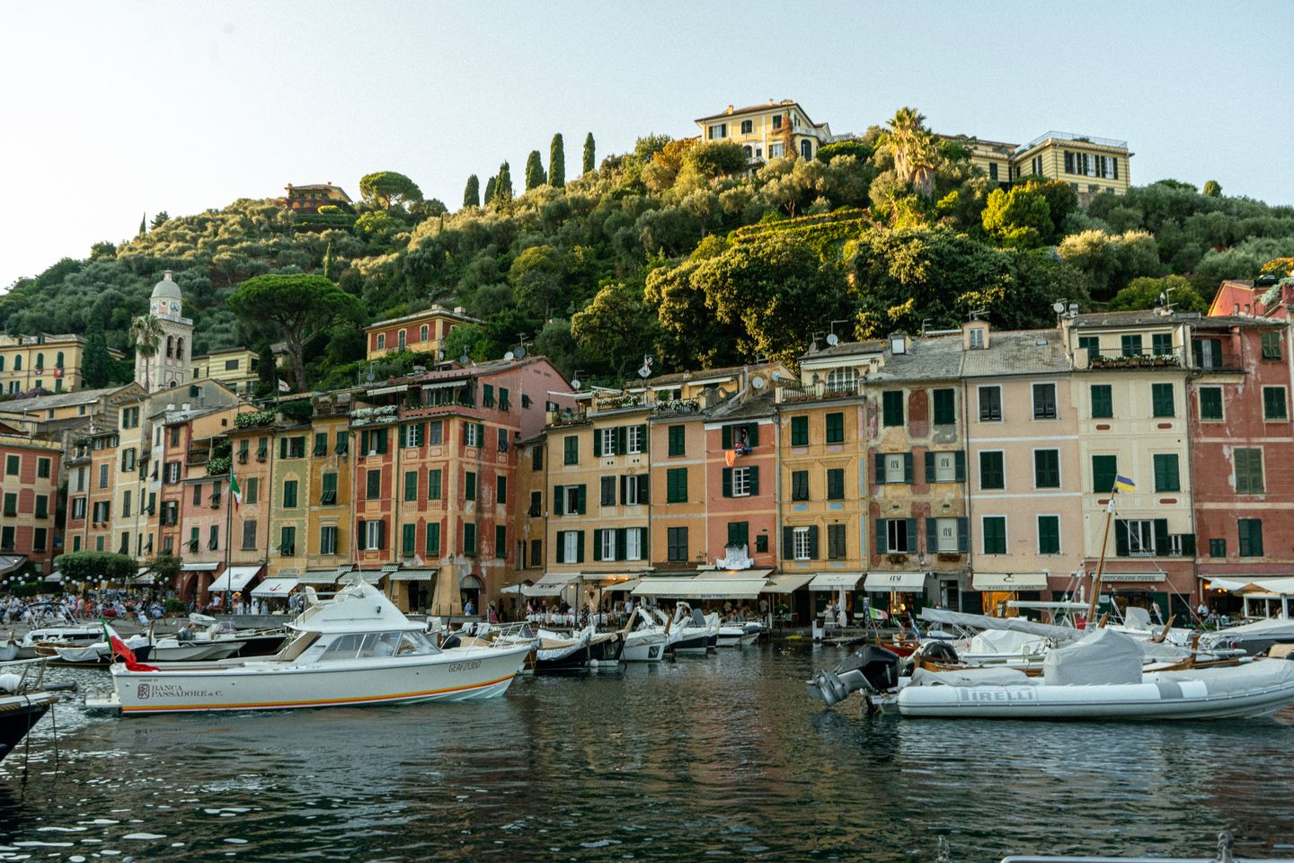 Encantadora vista del puerto en Portofino, Italia, con edificios coloridos y barcos atracados durante el atardecer.