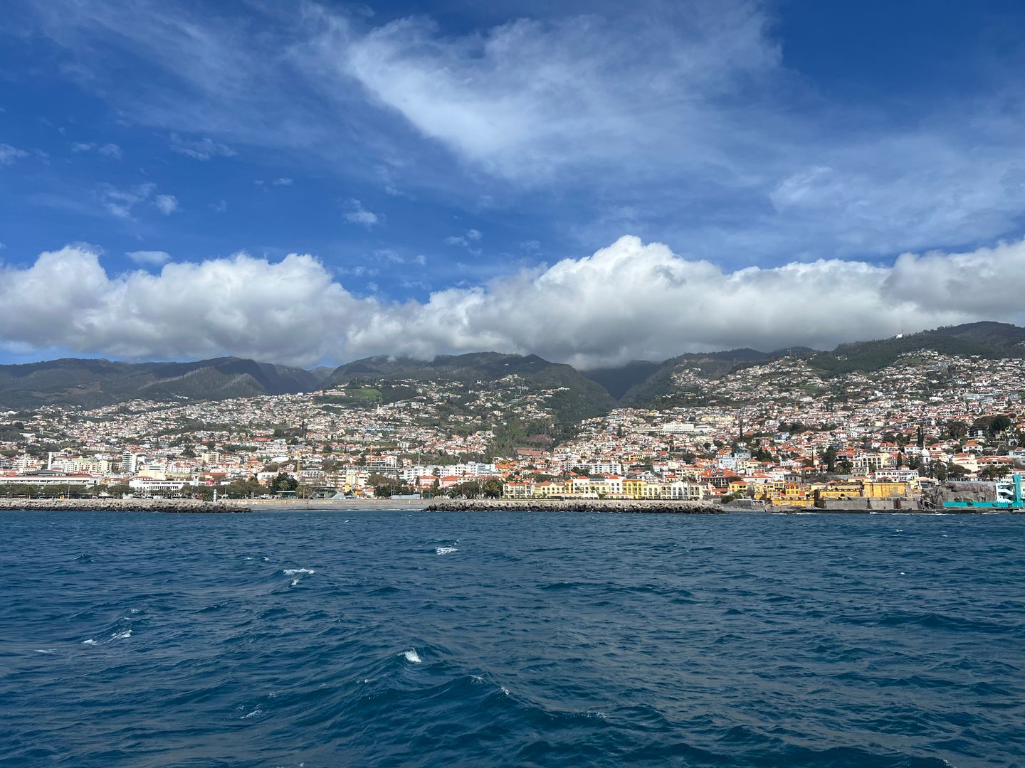 Hermosa vista costera de Funchal con océano azul y montañas bajo un cielo despejado.