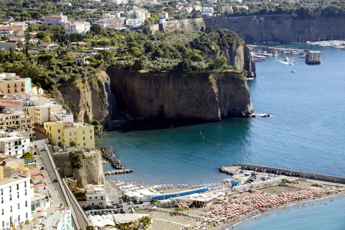 Impresionante toma aérea de los acantilados y la playa de Sorrento en Nápoles, Italia, con vistas vibrantes al mar.