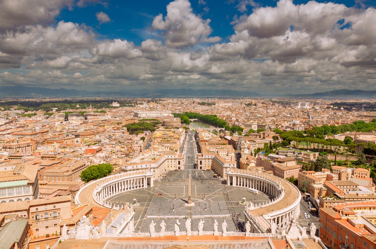 Impresionante toma aérea de la Plaza de San Pedro en la Ciudad del Vaticano que muestra sus icónicas columnatas y el horizonte de Roma.