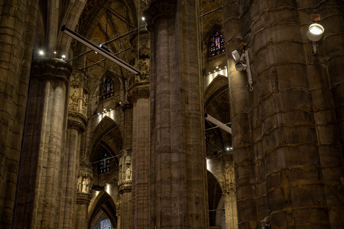 Majestuoso interior gótico de la Catedral de Milán con vidrieras y columnas altivas.