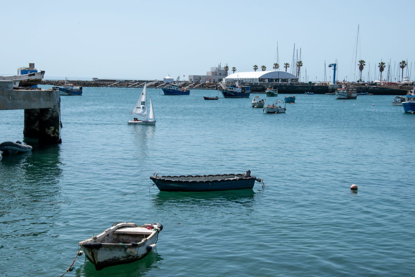 Una escena pacífica de barcos y yates en la marina de Cascais, Portugal, bajo un brillante cielo de verano.