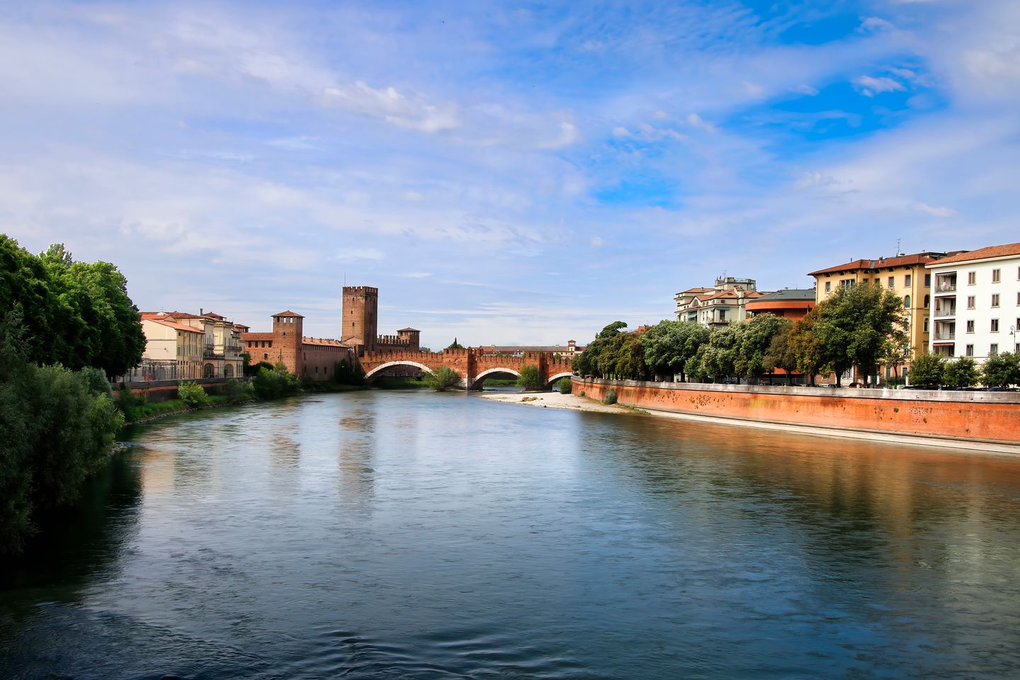 Vista pintoresca del puente Castelvecchio de Verona sobre el río Adige en un día soleado.