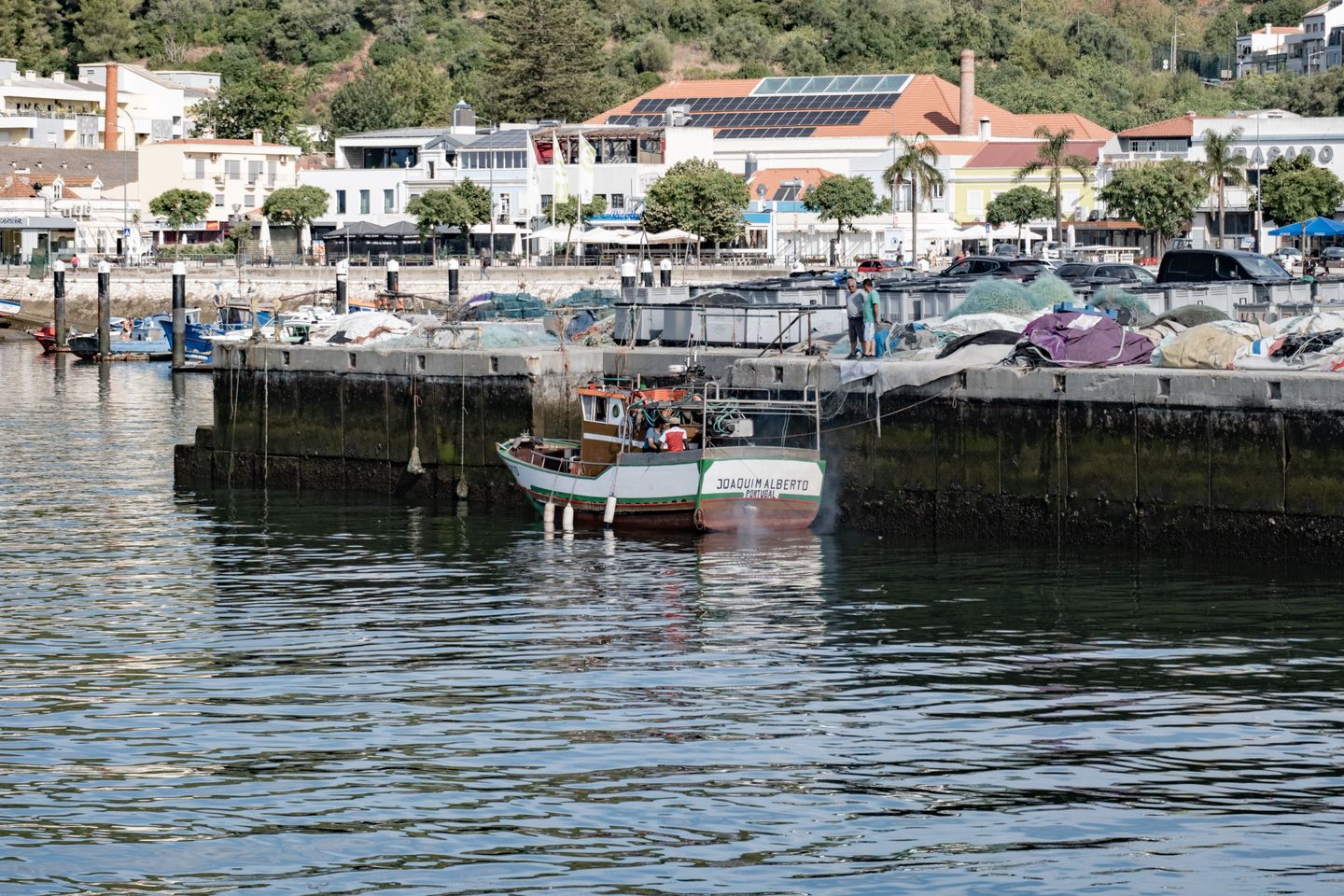 Un colorido barco de pesca atracado en el paseo marítimo de Setúbal, en un día soleado en Portugal.