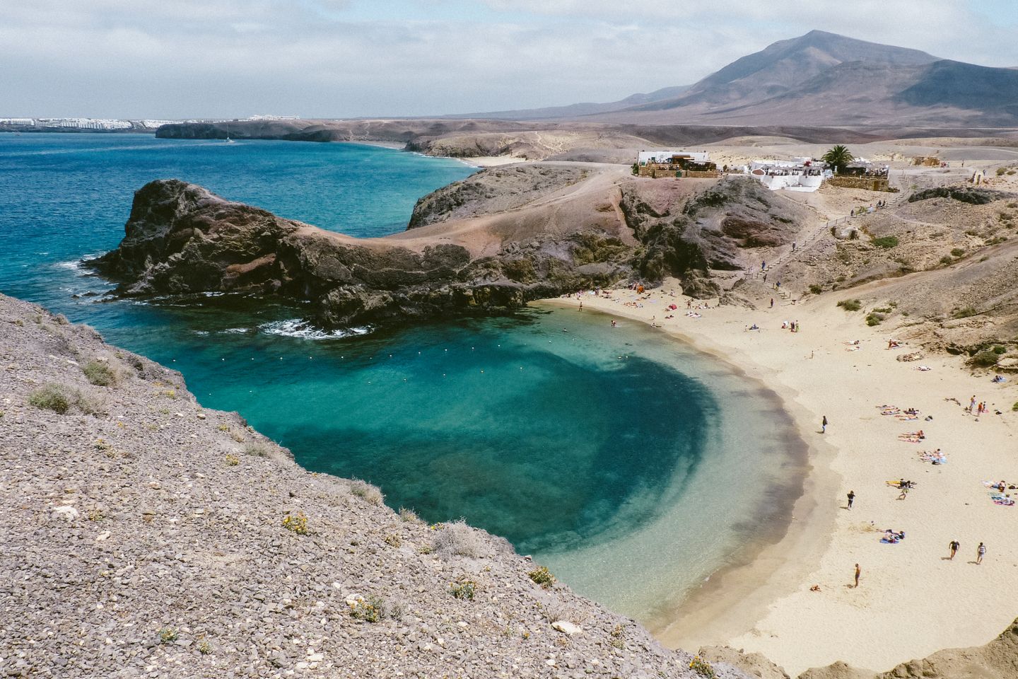 Explora la impresionante Playa Papagayo en la accidentada costa de Lanzarote, famosa por sus aguas turquesas.