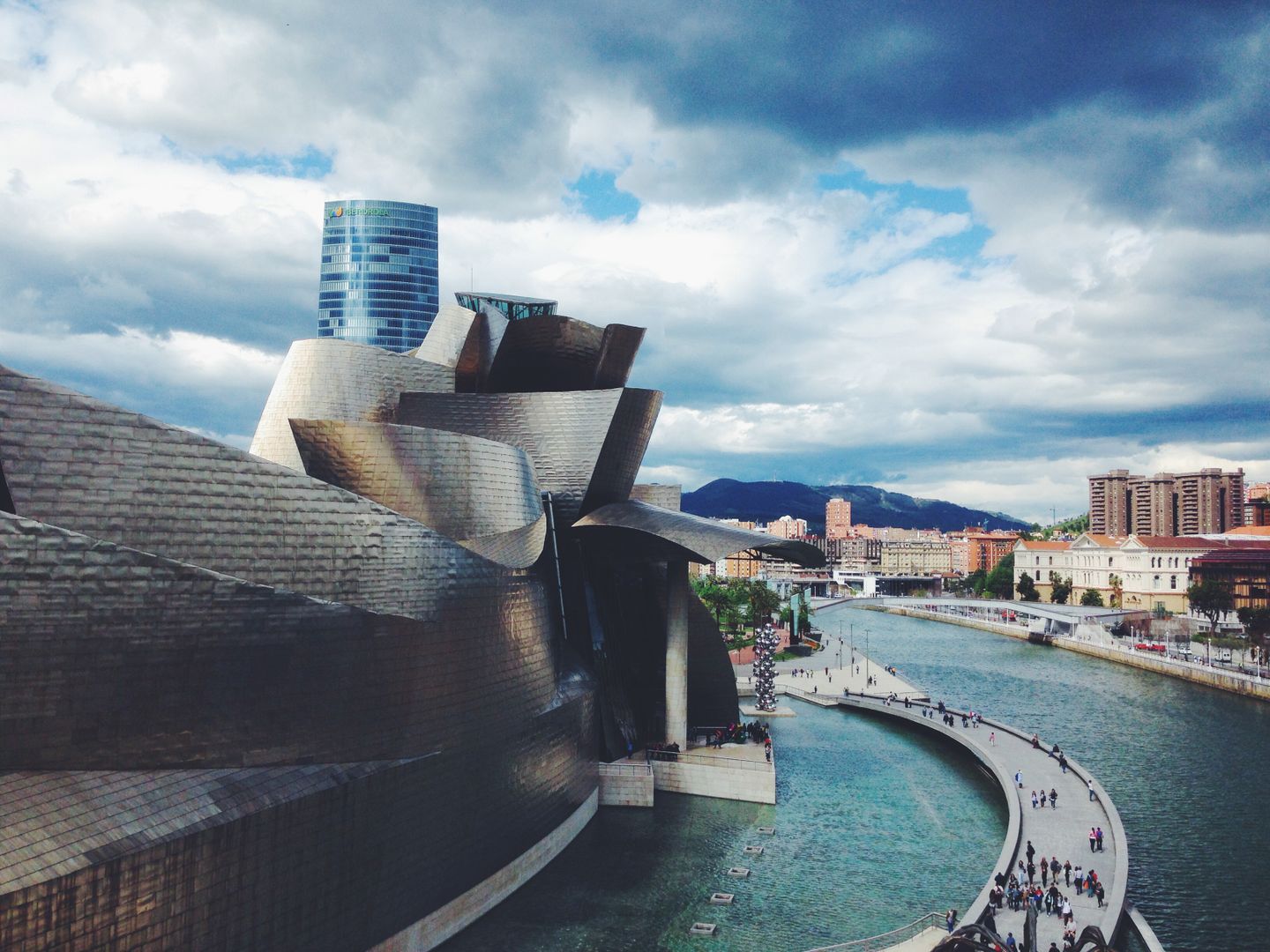 Arquitectura dinámica del Museo Guggenheim Bilbao con vista al río y al paisaje urbano.
