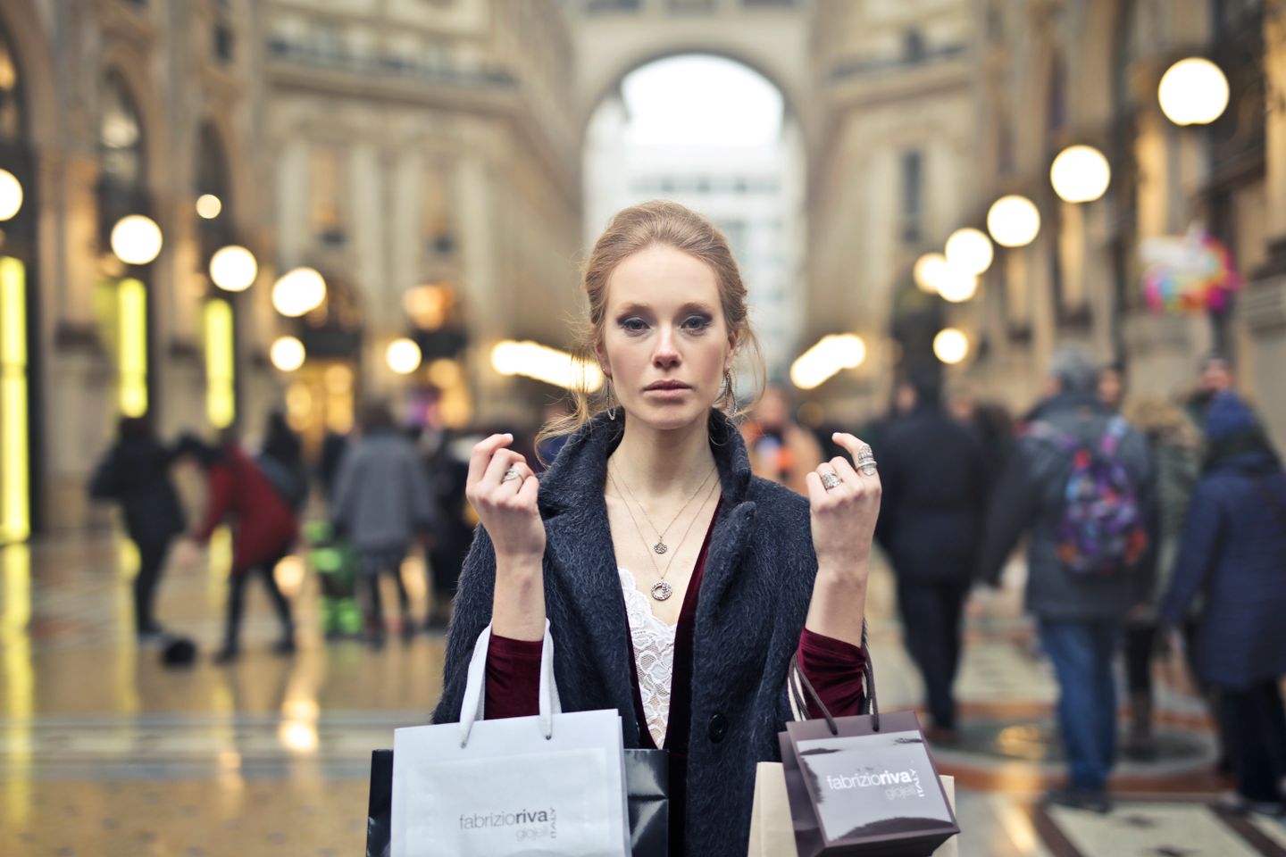 Mujer elegante haciendo compras con bolsas en la icónica Galleria Vittorio Emanuele II de Milán.